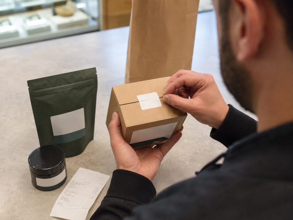 Adult checking a cannabis package security seal before leaving a dispensary
